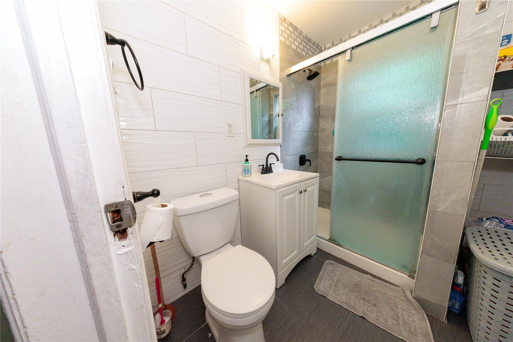 85-21 80th Street Queens, NY 11421 - Photo 28 of 39 a white toilet sitting next to a bathroom sink