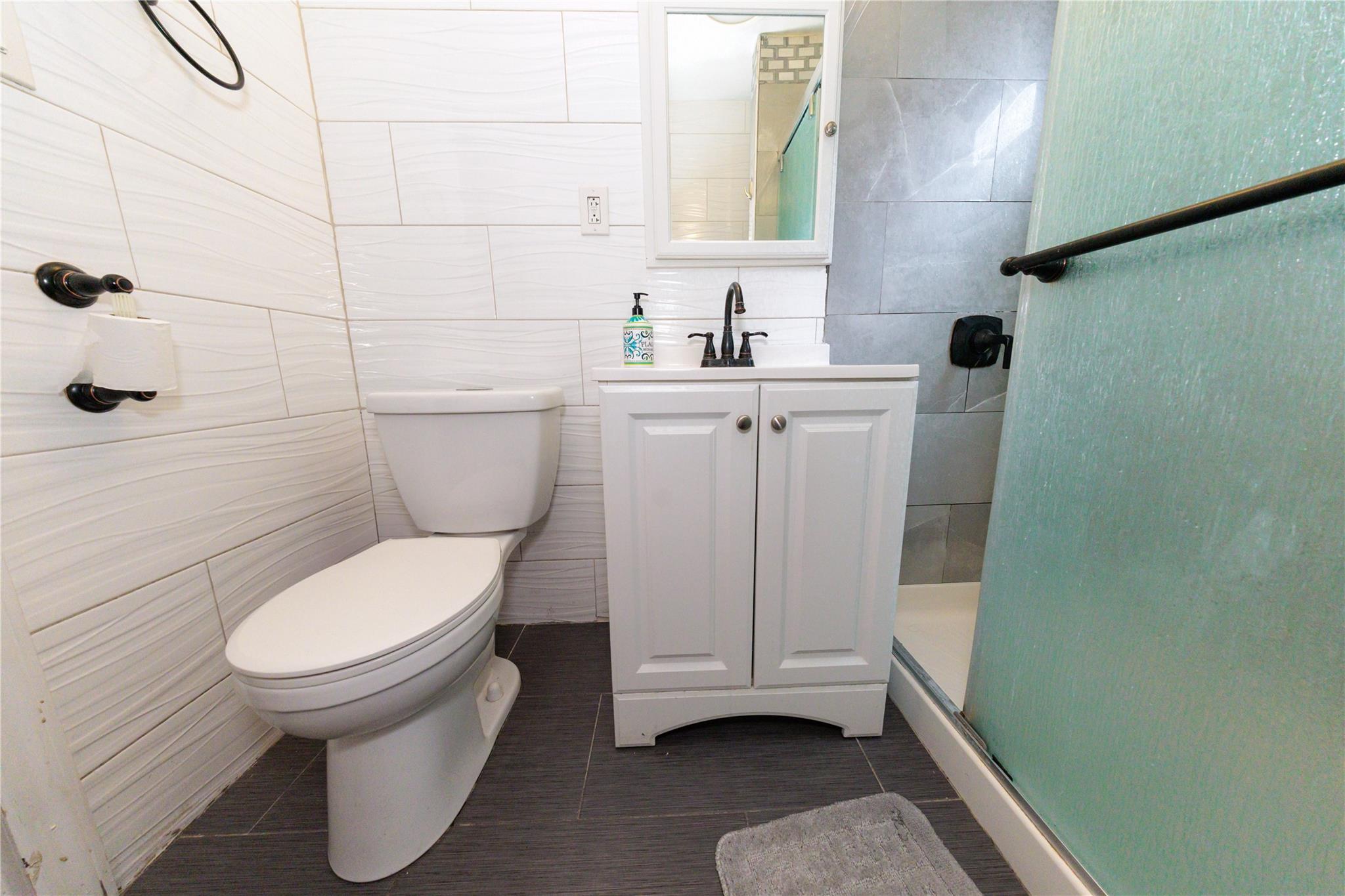 85-21 80th Street Queens, NY 11421 - Photo 29 of 39 a bathroom with a toilet and a sink