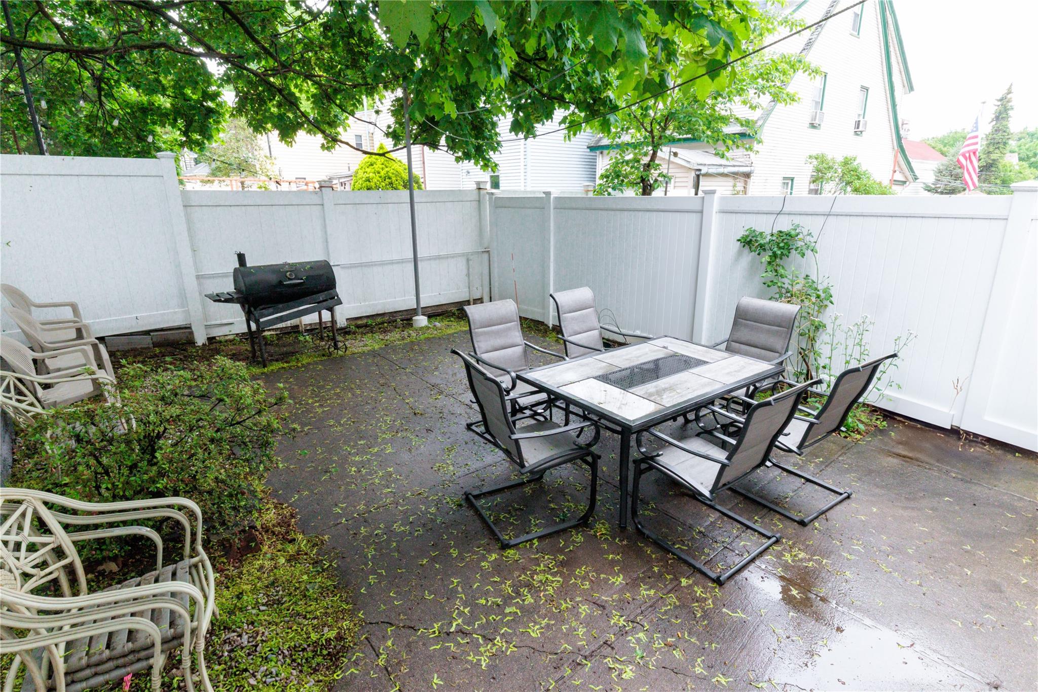 85-21 80th Street Queens, NY 11421 - Photo 35 of 39 a backyard of a house with table and chairs