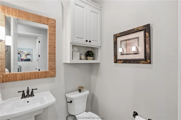 a bathroom with a toilet sink and mirror