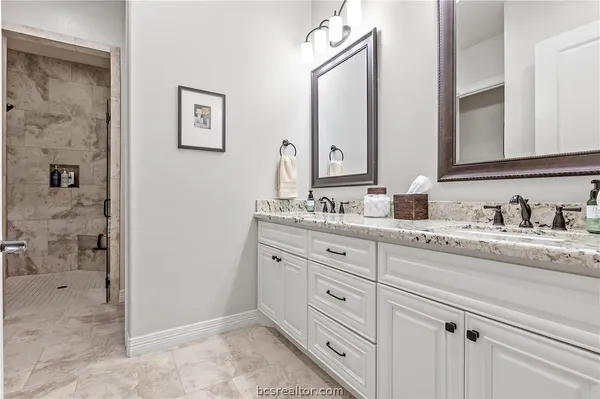 a bathroom with double sink and a mirror