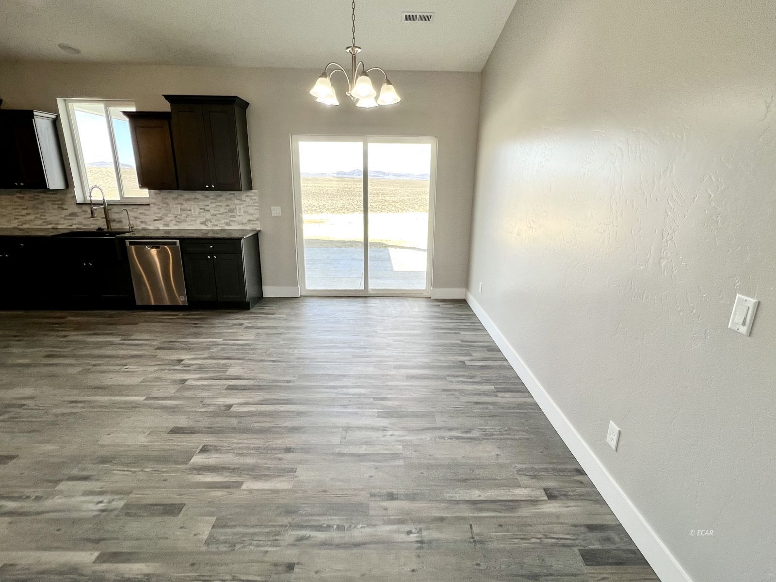 1151 Sun Vly Road Spring Creek, NV 89815 - Photo 20 of 30 a large kitchen with granite countertop a stove and a wooden floor