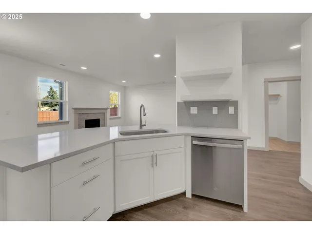 a kitchen with white cabinets and sink