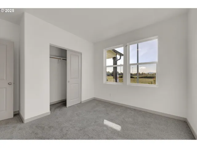 an empty room with windows and closet