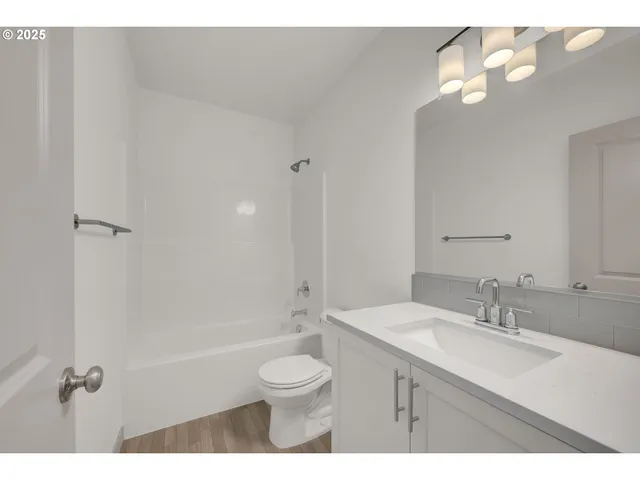 a bathroom with a granite countertop sink a toilet and shower