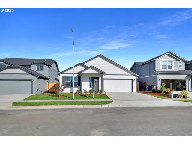 a view of a big house with a big yard and large trees