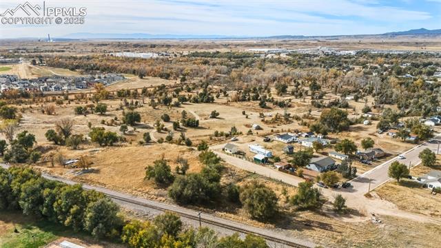 Aerial view of property and surrounding area featuring a mountainous background and rural landscape