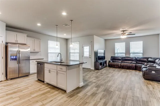 a kitchen with stainless steel appliances granite countertop a stove and a wooden floors