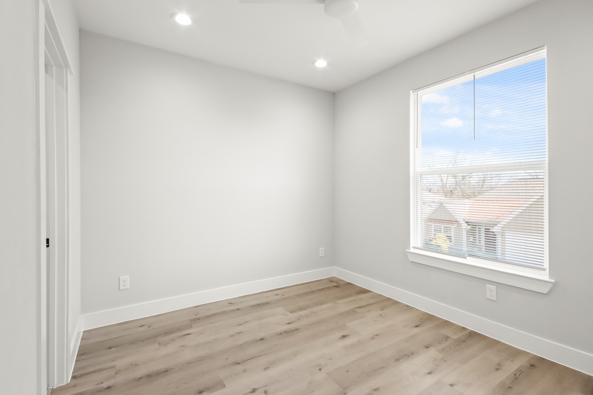 2105 Sam Wilson Street, Unit E Houston, TX 77020 - Photo 11 of 30 an empty room with wooden floor and windows