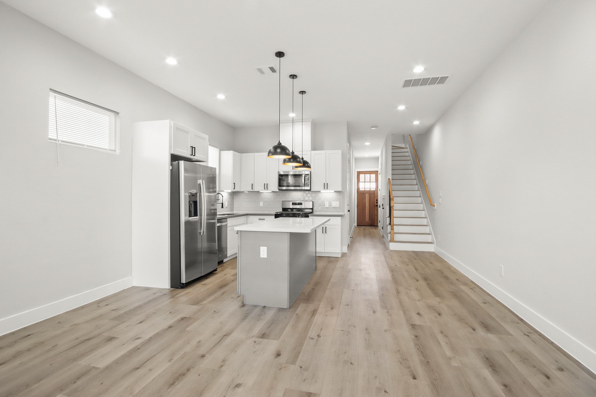 2105 Sam Wilson Street, Unit E Houston, TX 77020 - Photo 6 of 30 a open kitchen with white cabinets and stainless steel appliances