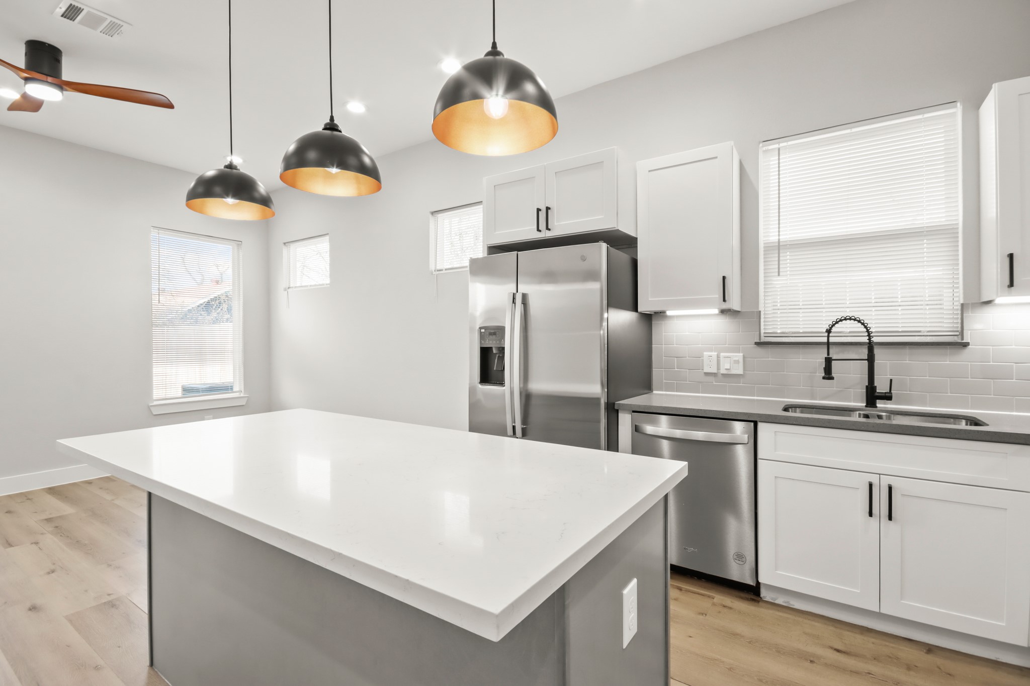 2105 Sam Wilson Street, Unit E Houston, TX 77020 - Photo 7 of 30 a kitchen with stainless steel appliances a sink a refrigerator center island and windows
