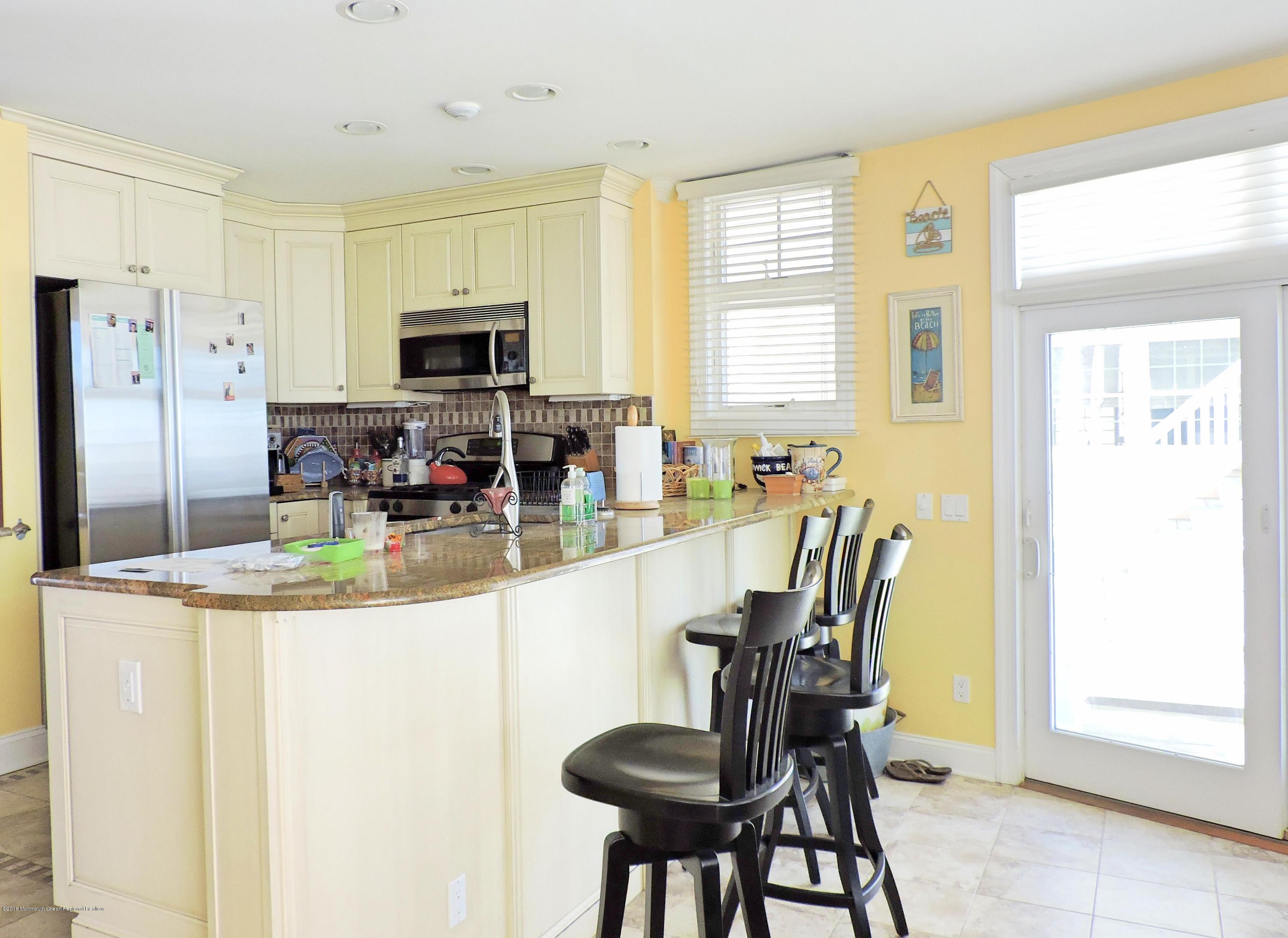3436 Ocean Road Lavallette, NJ 08735 - Photo 3 of 24 a kitchen with stainless steel appliances granite countertop a dining table chairs and a refrigerator