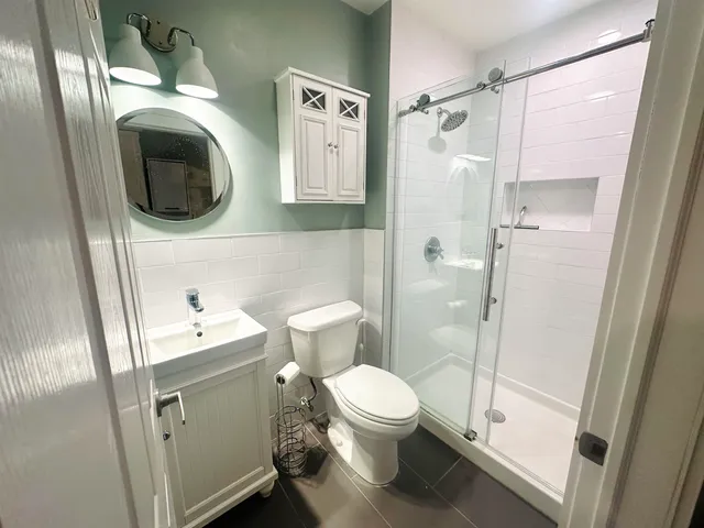 a bathroom with a toilet sink and mirror