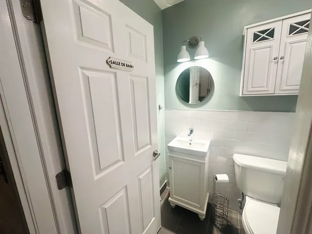 a bathroom with a sink mirror and toilet