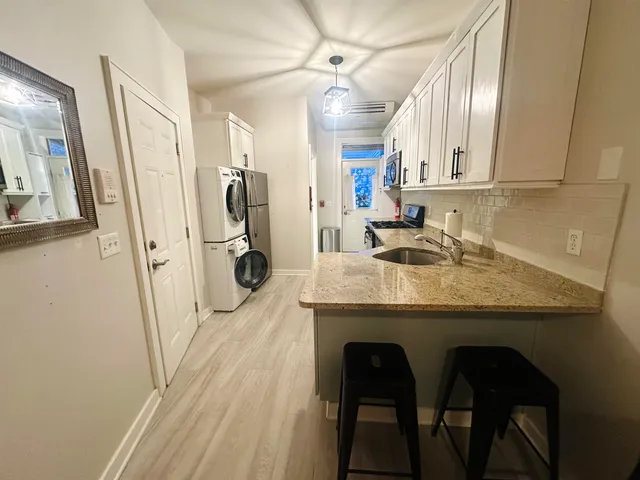 a kitchen with stainless steel appliances granite countertop a sink and a refrigerator