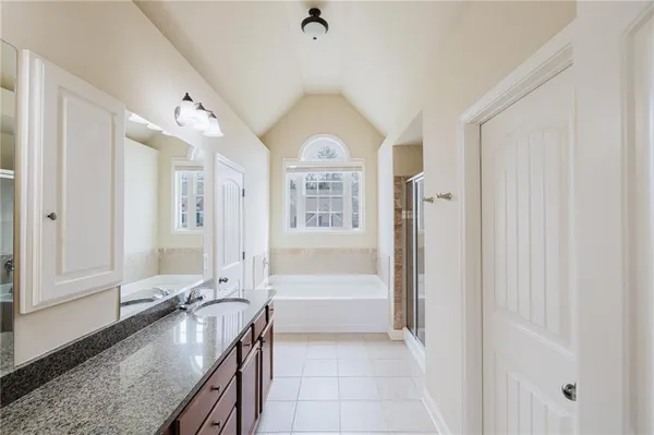 a large white kitchen with a granite countertop sink