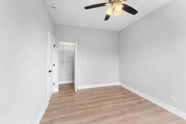 an empty room with a window and a fan