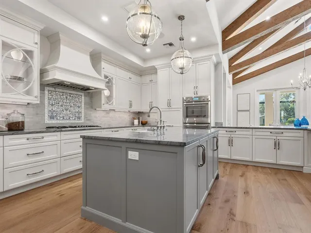 a kitchen with stainless steel appliances granite countertop a sink a counter space and cabinets