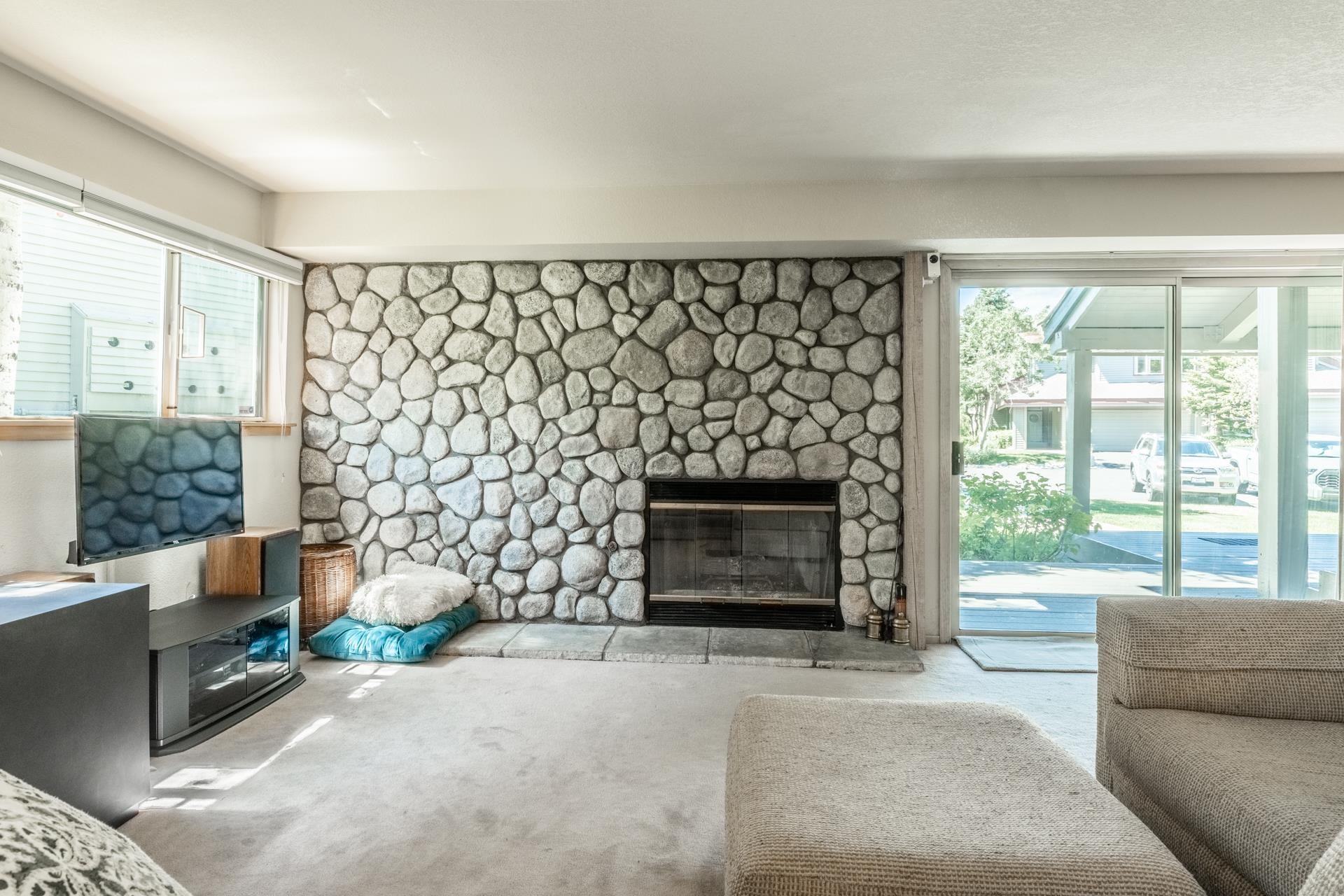 609 Golden Creek Road, Unit 609 Mammoth Lakes, CA 93546 - Photo 18 of 42 Living area featuring a floor-to-ceiling stone fireplace, a stone hearth, and an integrated firebox