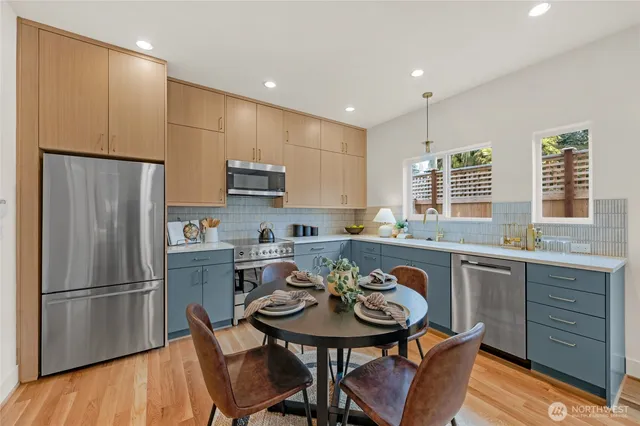 a kitchen with refrigerator a sink and chairs
