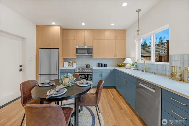 a kitchen with stainless steel appliances kitchen island granite countertop a sink a stove a kitchen island with chairs and cabinets