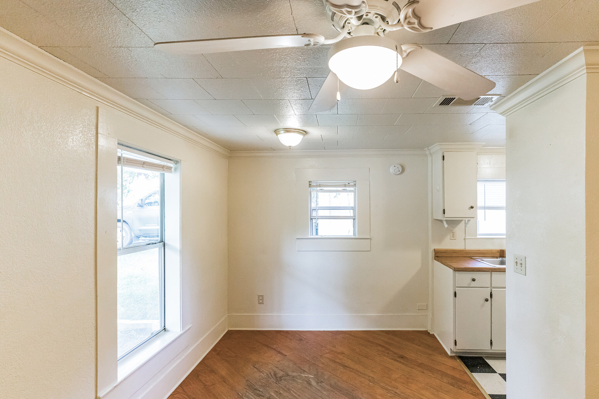 501 East 4th Street Georgetown, TX 78626 - Photo 9 of 25 Unfurnished dining area featuring dark wood finished floors, crown molding, ceiling fan, and plenty of natural light