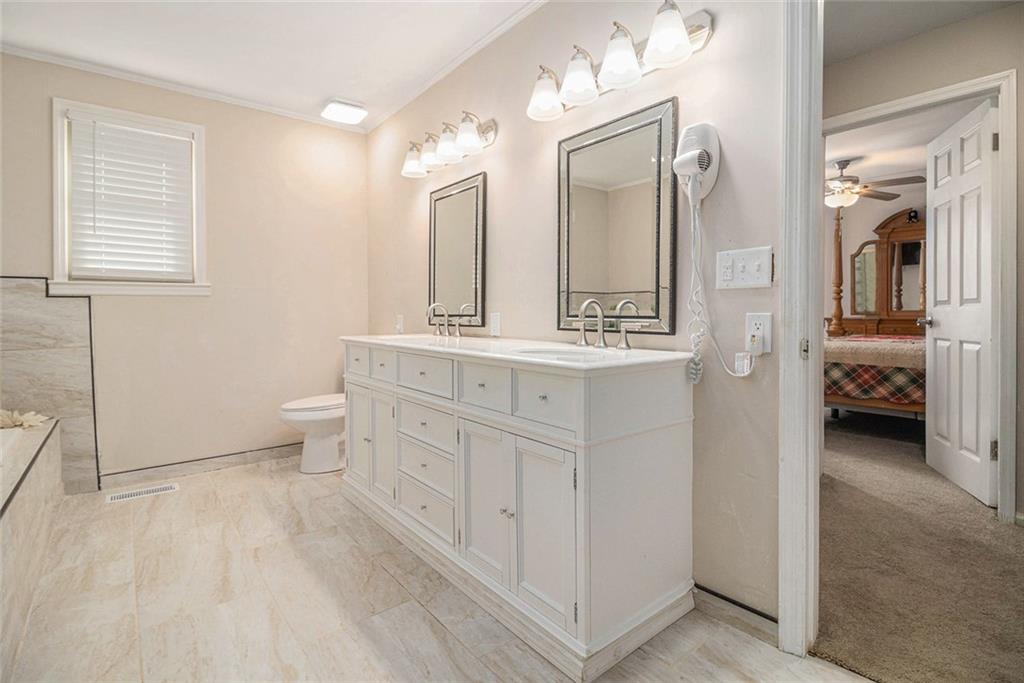 128 Highland Drive West Point, GA 31833 - Photo 19 of 22 a spacious bathroom with a double vanity sink toilet and mirror