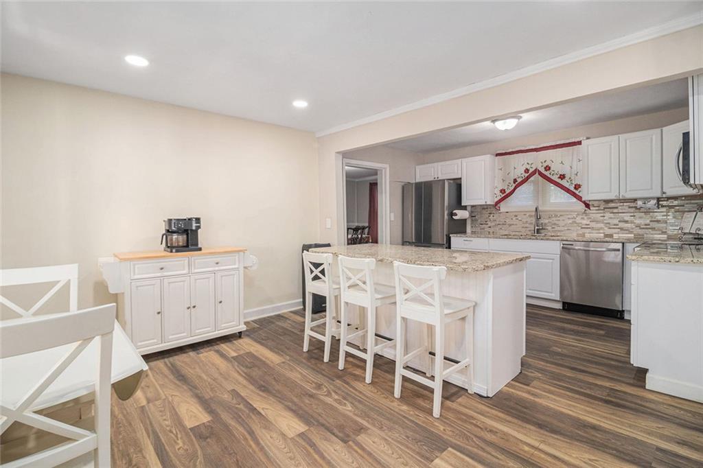 128 Highland Drive West Point, GA 31833 - Photo 6 of 22 a kitchen with stainless steel appliances a dining table chairs and wooden floor