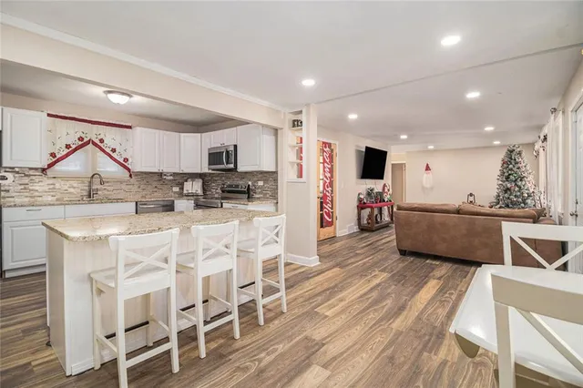 a kitchen with stainless steel appliances kitchen island granite countertop a sink and cabinets