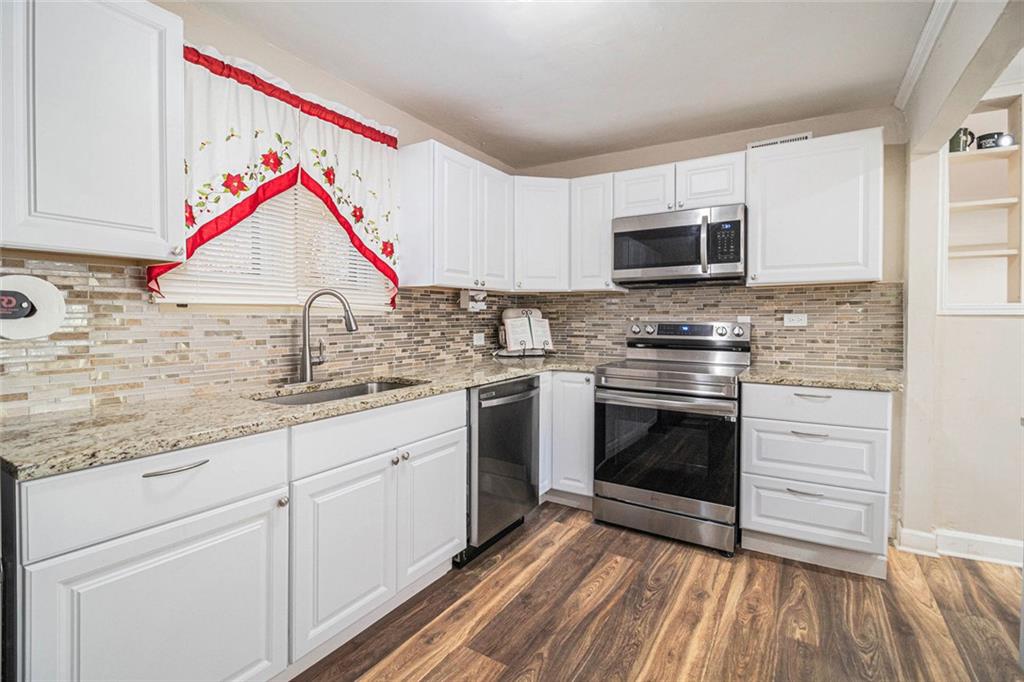 128 Highland Drive West Point, GA 31833 - Photo 8 of 22 a kitchen with stainless steel appliances granite countertop a stove a sink and a microwave