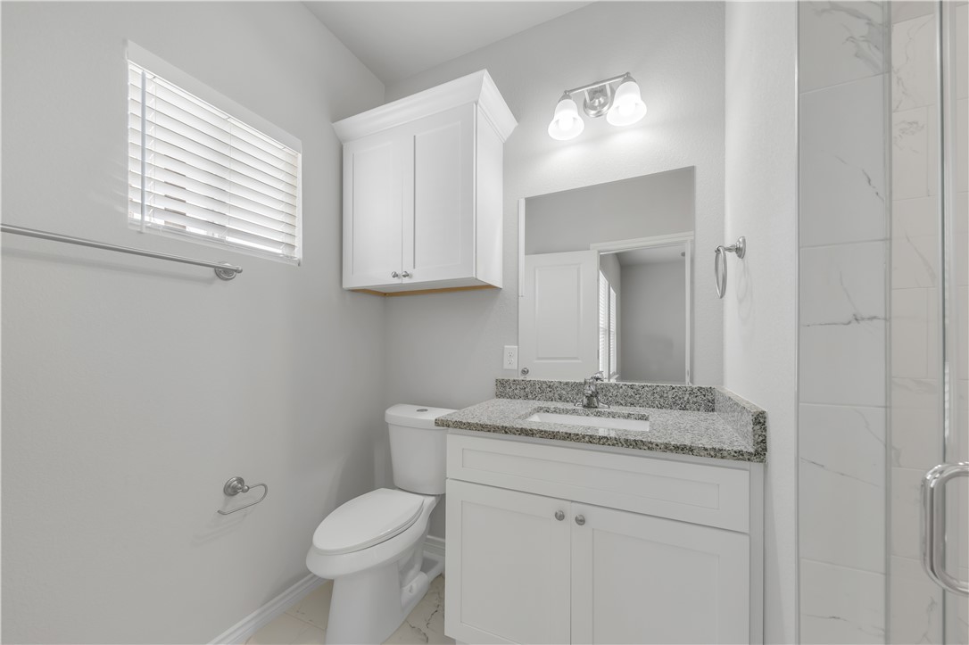 1805 Pin Oak Street Bryan, TX 77803 - Photo 4 of 20 Full bath featuring vanity, a shower stall, and marble look tiles