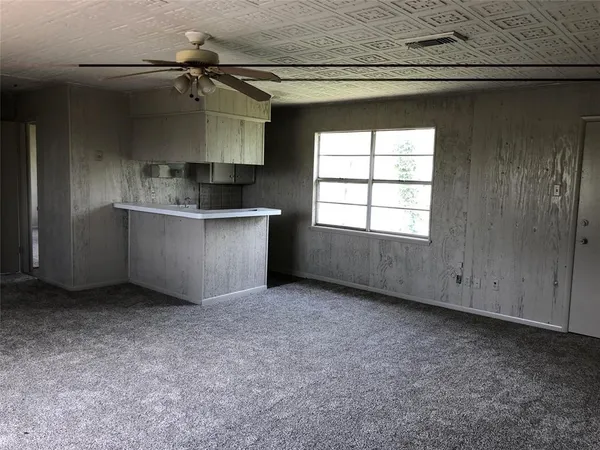 an empty room with a fireplace and windows