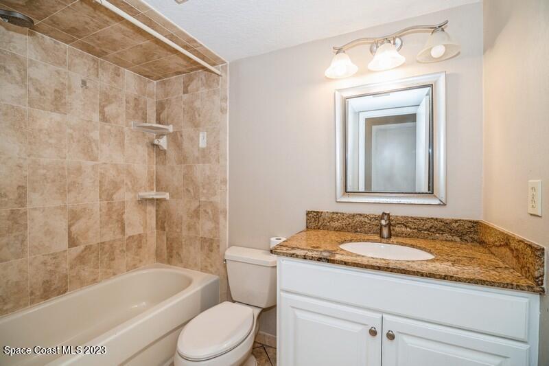 2418 Delys Street Cocoa, FL 32926 - Photo 11 of 12 a bathroom with a granite countertop sink a toilet and bathtub