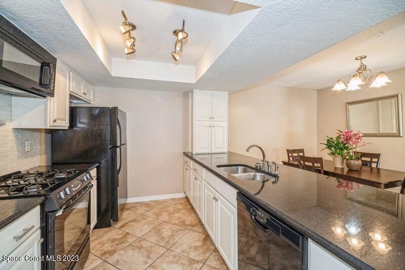 2418 Delys Street Cocoa, FL 32926 - Photo 2 of 12 a kitchen with stainless steel appliances granite countertop a sink a stove and a refrigerator