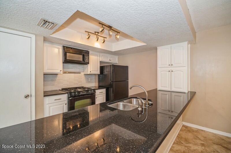 2418 Delys Street Cocoa, FL 32926 - Photo 3 of 12 a kitchen with kitchen island a stove and a sink