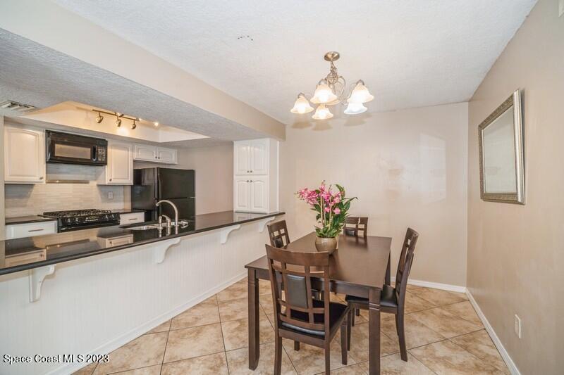 2418 Delys Street Cocoa, FL 32926 - Photo 4 of 12 a dining room with furniture and chandelier