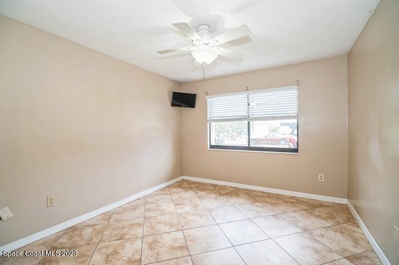 2418 Delys Street Cocoa, FL 32926 - Photo 10 of 12 an empty room with windows and ceiling fan