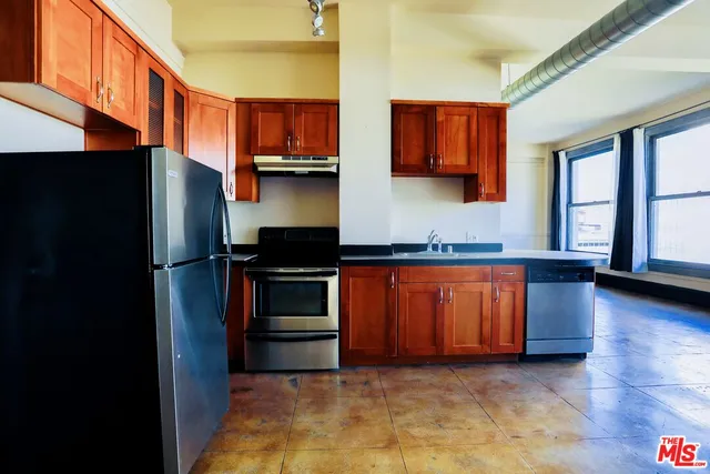 a kitchen with stainless steel appliances granite countertop a refrigerator and a sink