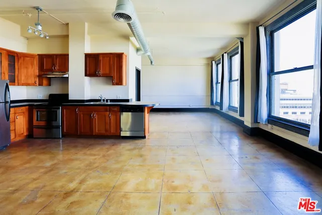 a view of a kitchen with kitchen island a sink wooden floor and a large window