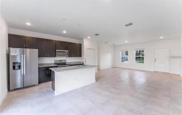 a kitchen with stainless steel appliances granite countertop a refrigerator oven a sink and dishwasher