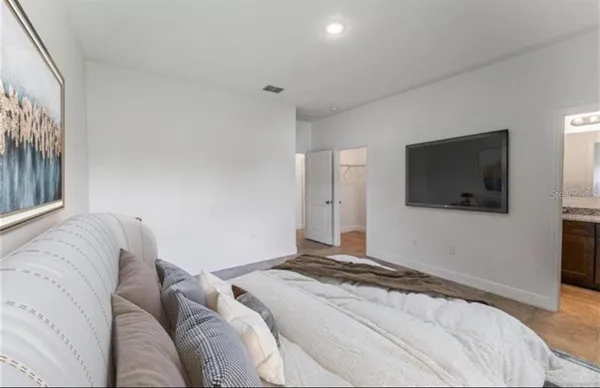 a bedroom with a large bed and a flat screen tv
