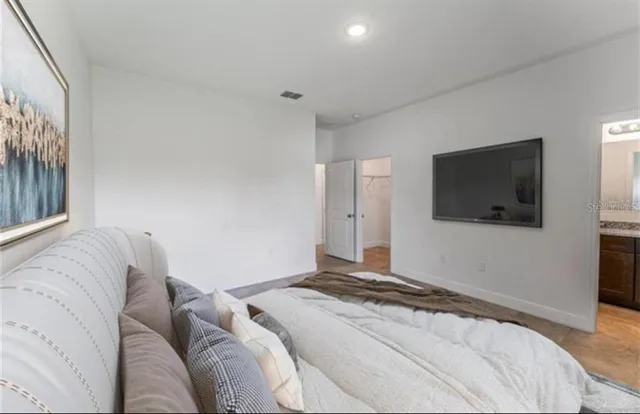 a bedroom with a large bed and a flat screen tv