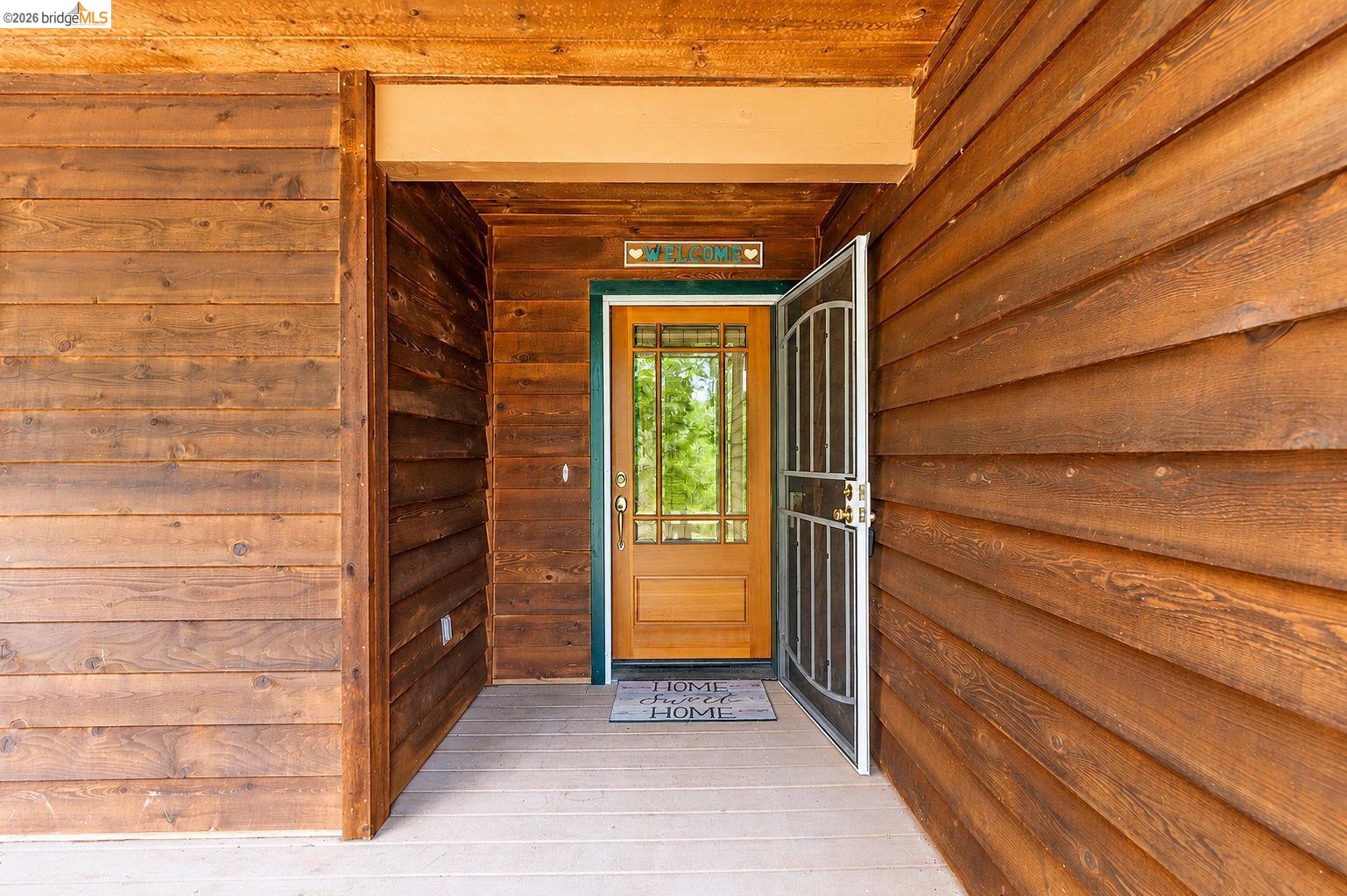 22401 Ridge Road Twain Harte, CA 95383 - Photo 6 of 56 Covered entry with natural wood-finish siding and a light wood-finish door featuring decorative glass