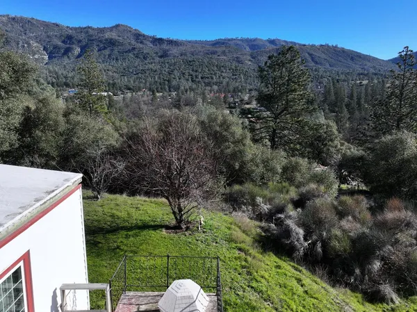 a view of a lush green hillside and a building