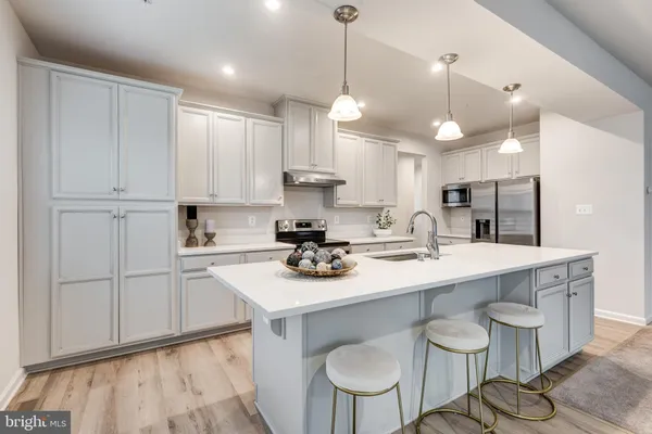 a kitchen with stainless steel appliances granite countertop a sink stove and cabinets