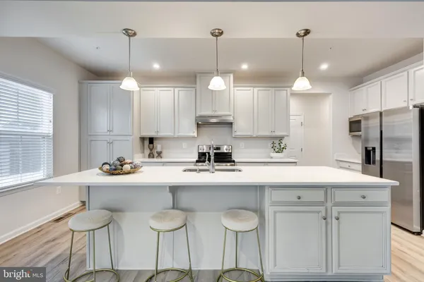 a kitchen with stainless steel appliances granite countertop a sink a stove and a refrigerator