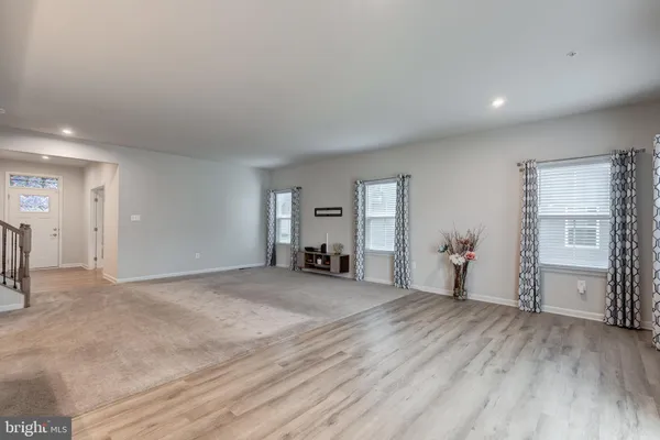 a kitchen with white cabinets stainless steel appliances and chairs