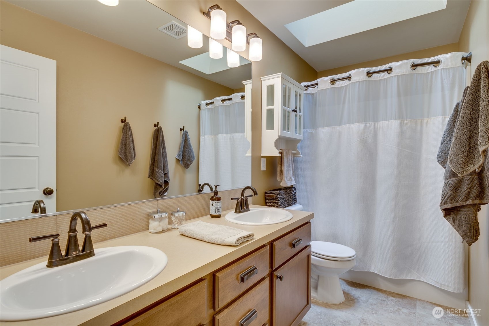 3119 223rd Street Southeast Bothell, WA 98021 - Photo 23 of 40 a bathroom with double vanity sink a toilet a mirror and shower curtain