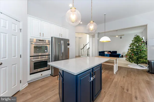 a kitchen with kitchen island granite countertop a sink refrigerator and cabinets