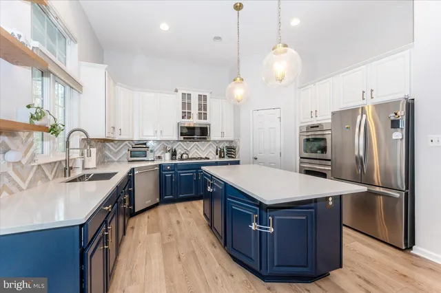 a kitchen with stainless steel appliances granite countertop a sink refrigerator and cabinets